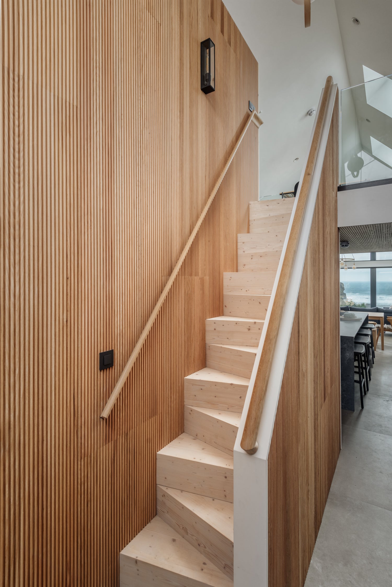 Irregular wooden staircase with fluted wooden panels on the right-hand wall, by Element.