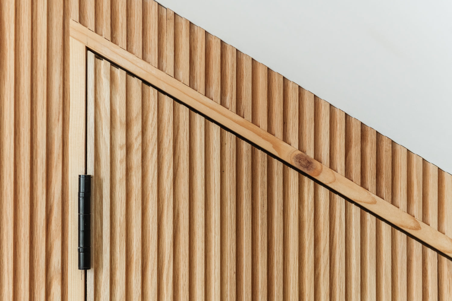 Understairs Door with Oak and Beach fluted panelled walls and door, creating Oku lines. Made By Element Case Study