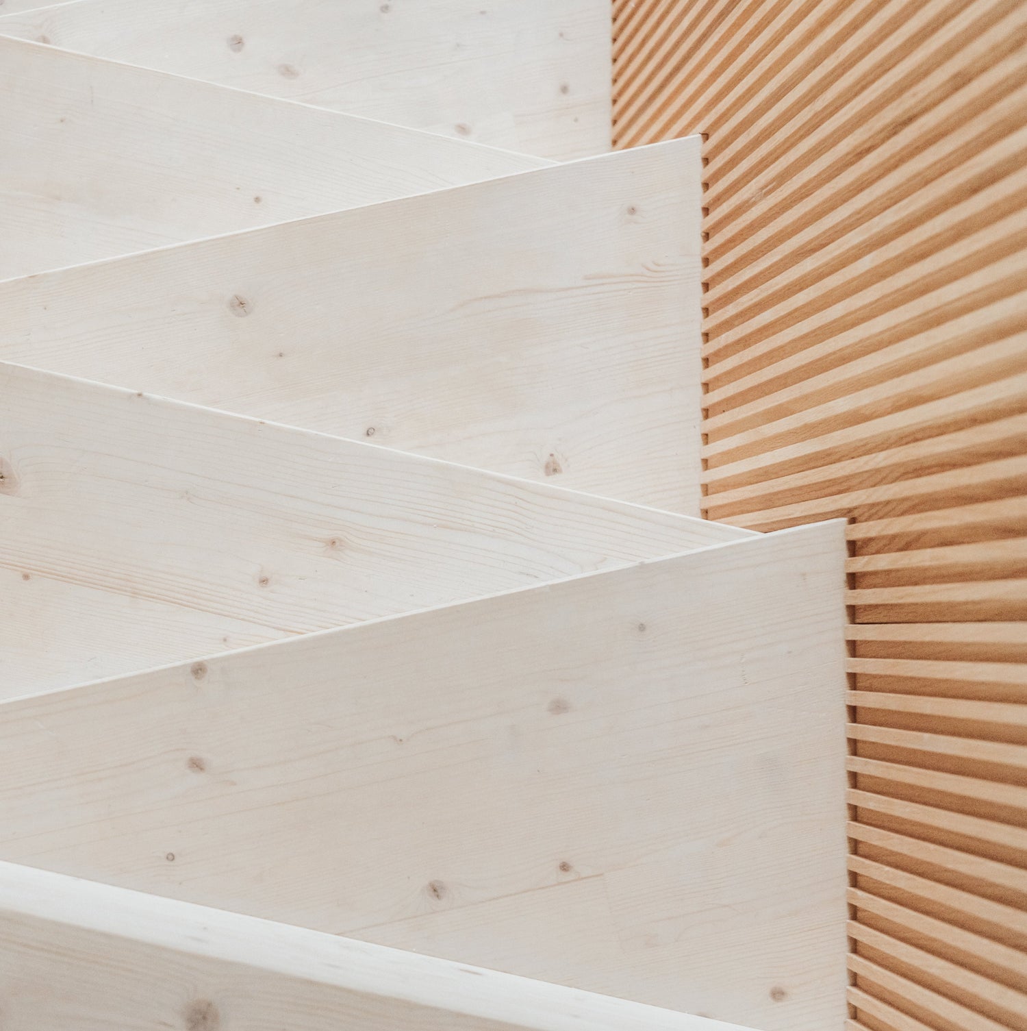 Irregular wooden staircase with fluted wooden panels on the left-hand wall, by Element.